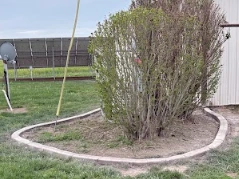 Concrete curbing installed around solar panel array with mulch bed